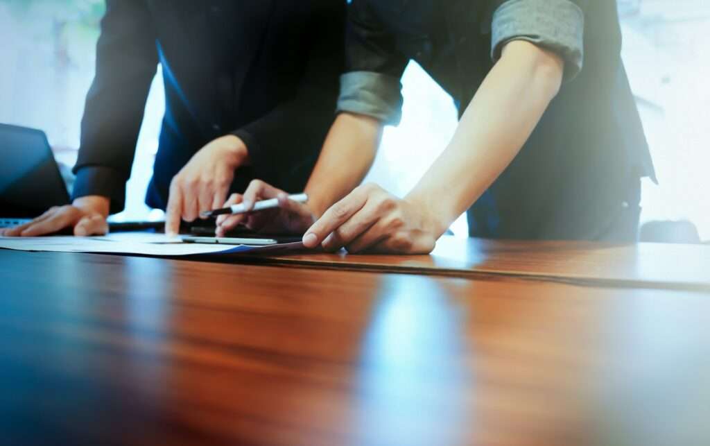 Two people holding a paper