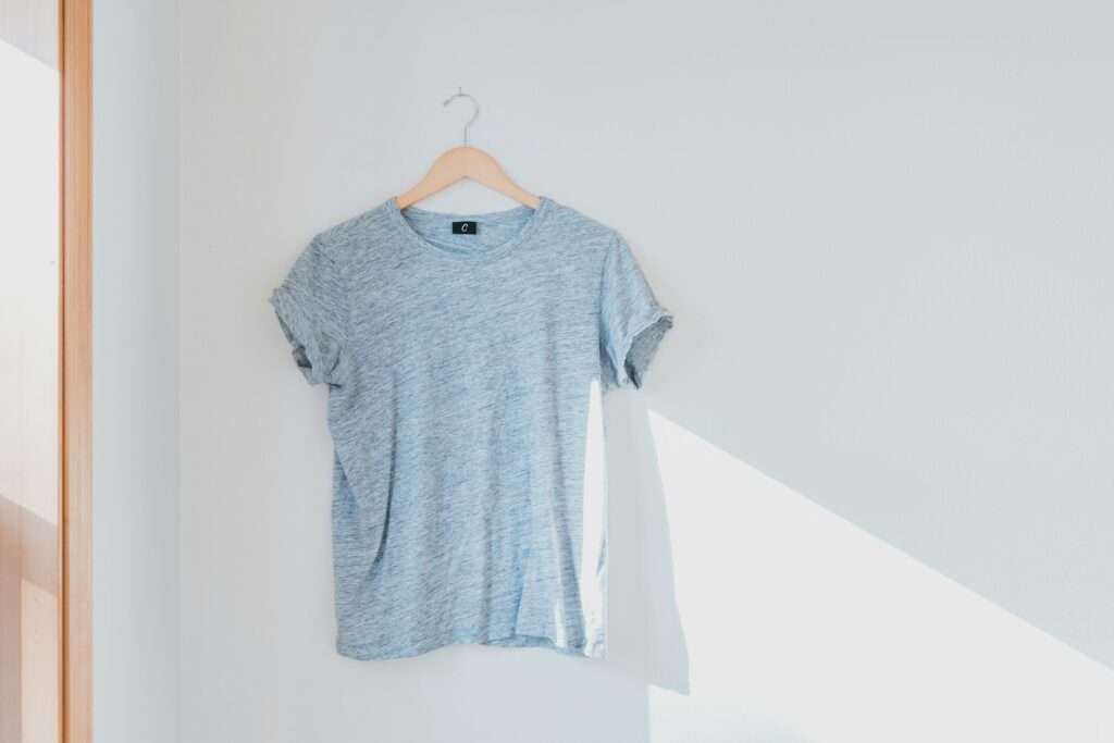 Hanged grey shirt on white wall