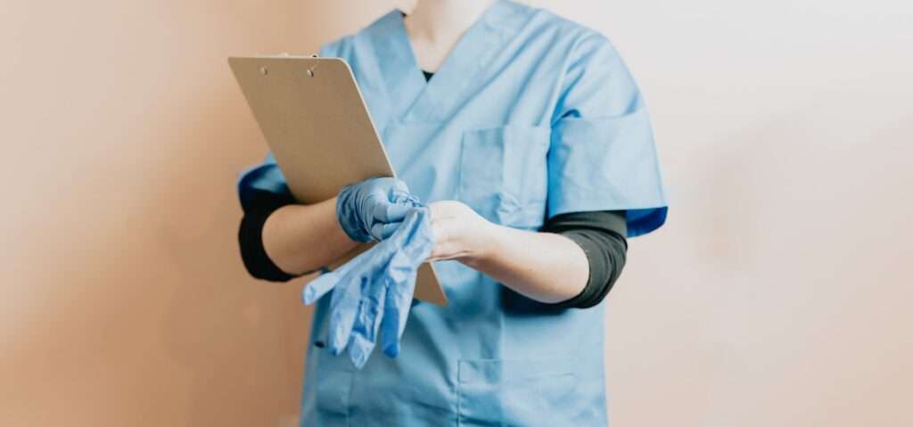 A person in scrubs holding a paper