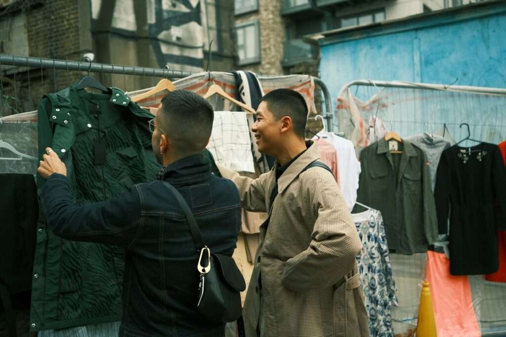 Couple of men standing next to a clothing store