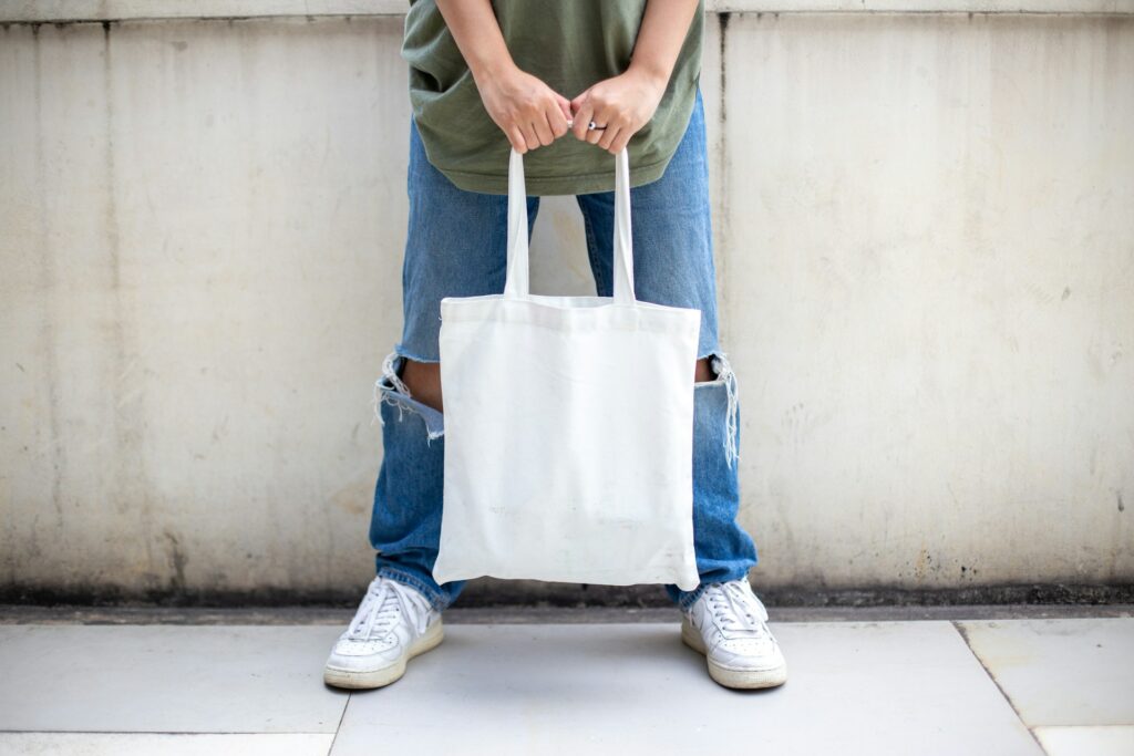 A white tote bag being held by a person image