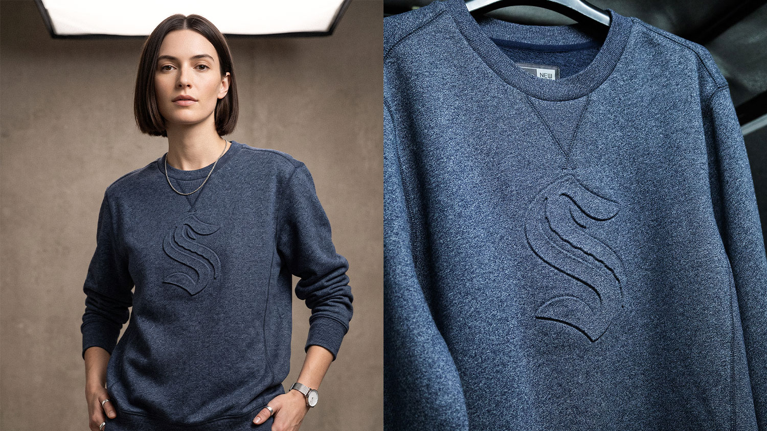 Model wearing a dark blue sweatshirt with an embossed curved logo on the chest.
