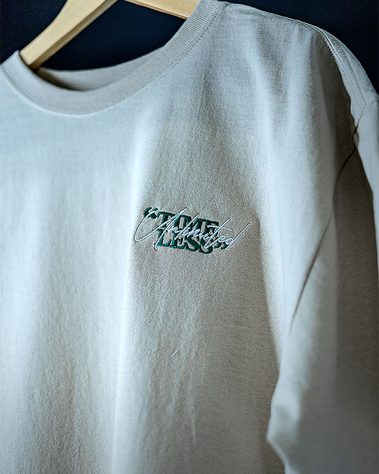 Grey sweatshirt on a wooden hanger with a small embroidered logo on the chest area.