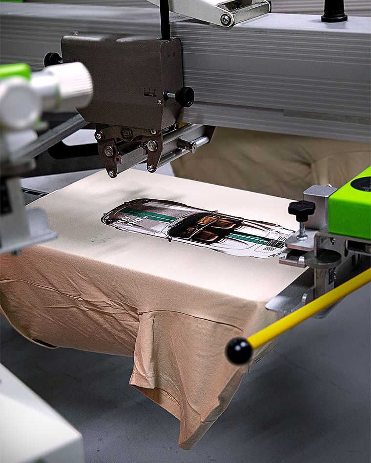 Industrial textile printer applying a graphic to beige fabric on a conveyor system